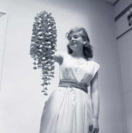 Woman holding Christmas decoration made of milk bottle tops Wellington 1957 edit copy